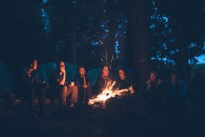 Group of friends camping around a fire